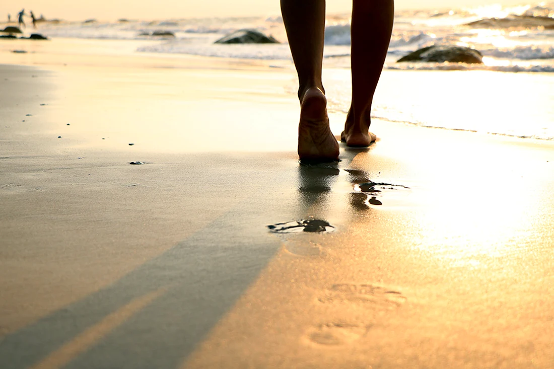 Девушка идет по песку