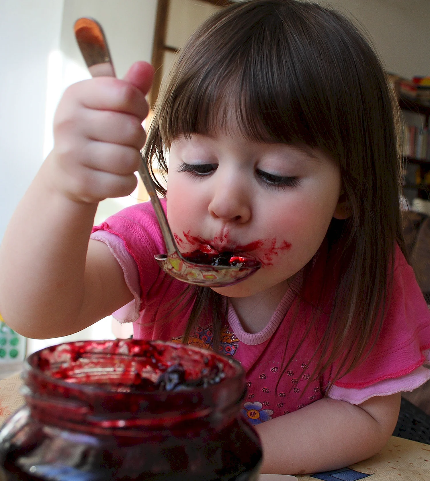 Девочка ест варенье