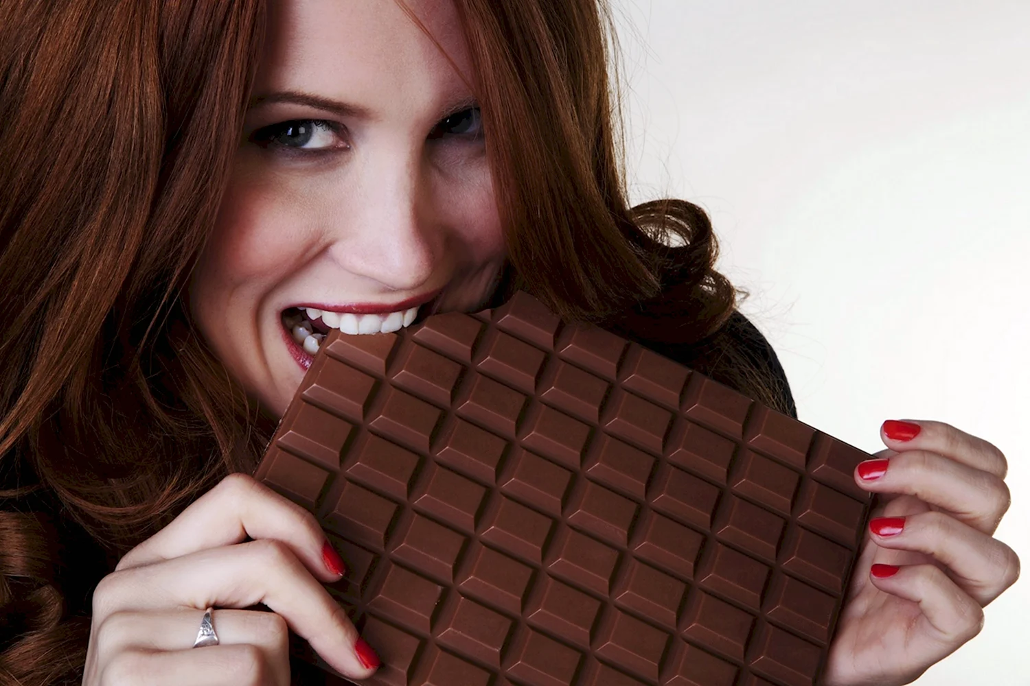 Девушка ест шоколадку